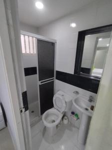 a bathroom with a toilet and a sink at Hotel BM-17 Cerca Al Mar Con Aire Acondicionada y Wifi in Cartagena de Indias