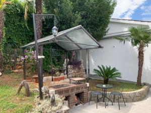 un patio con mesa, sillas y chimenea en Villa Nika 3, en Ika
