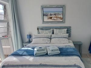 a bedroom with a bed with two towels on it at Amazing Grace B&B in Gansbaai