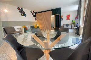 een eetkamer met een glazen tafel en stoelen bij Modern City Apartment l Netflix l fast wifi l Xbox in Berlijn