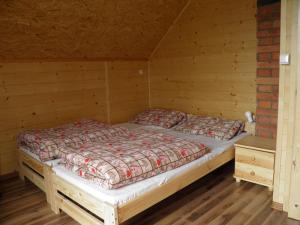 a bedroom with a bed in a cabin at Domek pod Lipą in Korbielów