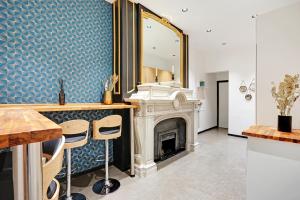 ein Wohnzimmer mit einem Kamin und einem Spiegel in der Unterkunft CMG Champs Elysées - Boetie 7 in Paris