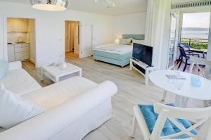 een woonkamer met een bank, een bed en een tafel bij fewo1846 - Fjordview - komfortables Studioapartment mit Balkon und Meerblick in Glücksburg