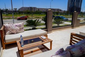 ein Wohnzimmer mit einem Sofa und einem Tisch auf dem Balkon in der Unterkunft Villa 55 in Madinat as-Sadis min Uktubar