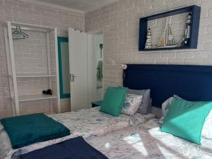 a bedroom with a bed with a blue head board at Amazing Grace B&B in Gansbaai