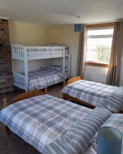 CreetownにあるPibble Cottageの二段ベッド2台と窓が備わる客室です。