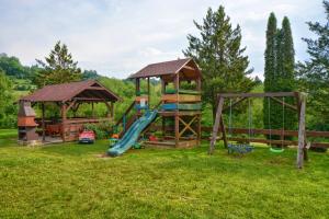 un parque infantil con tobogán y cenador en Domki na Zaciszu, en Zawóz