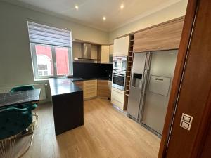 a kitchen with stainless steel appliances and wooden floors at Sara’s Apartment in Mariánské Lázně