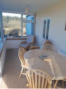a dining room with a table and chairs and a window at Pibble Cottage in Creetown