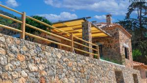 una casa que se está construyendo sobre una pared de piedra en Casa Diosa en Palaiochóra