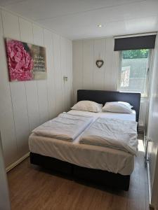 エグモント・アーン・デン・フフにあるZomerhuis Duinzichtのベッドルーム1室(白いシーツが敷かれた大型ベッド1台、窓付)