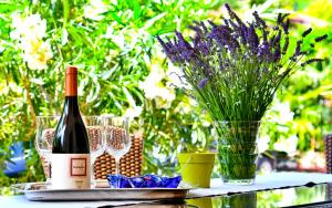 a bottle of wine on a table with glasses and flowers at Apartment Dolores in Mošćenička Draga