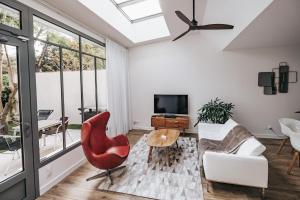 a living room with a red chair and a couch at 64 Sur Le Mail in La Rochelle