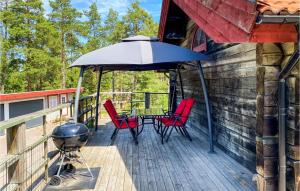 een terras met een grill en stoelen en een parasol bij Stunning Home In Figeholm With Kitchen in Figeholm