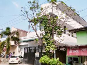 een boom voor een gebouw bij SPOT ON 92749 As-sakinah Syariah 2 in Medan