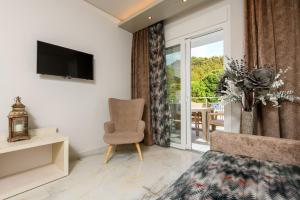 a living room with a chair and a sliding glass door at Sunny Memories Apartments in Limenas