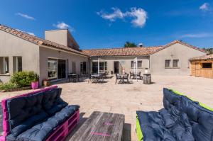 a patio with couches and tables in a house at Camping des Templiers in Le Caylar