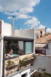 eine Person, die auf einem Fenster eines Gebäudes sitzt in der Unterkunft La Llar D'aitana in Alcoleja