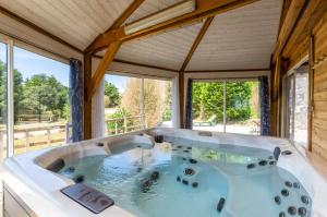 bañera grande en una habitación con ventanas en Camping des Templiers, en Le Caylar