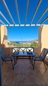 a table and chairs in a room with a view at Villa Possidonia Syros in Ano Syros