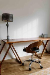 escritorio de madera con silla y altavoz en The Studio Apartment - Nottingham Road, en Nottingham Road