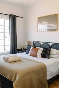 1 dormitorio con 2 camas con almohadas y ventana en The Studio Apartment - Nottingham Road en Nottingham Road