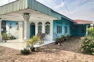 棉蘭的住宿－SPOT ON 92697 Ani Nur Homestay Syariah，蓝色和白色的房屋,设有庭院