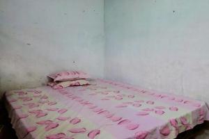 1 dormitorio con 1 cama con sábanas rosas y rosas en SPOT ON 92697 Ani Nur Homestay Syariah, en Medan