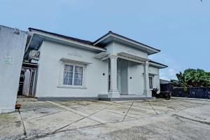 una casa blanca con una entrada delante de ella en OYO 92708 Hotel Mufasa Syariah en Pangkalpinang