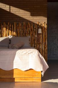 um quarto com uma cama e uma cabeceira em madeira em Sertão do Luar em Jurubeba