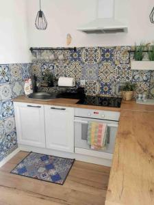 a kitchen with white cabinets and a sink and tiles at Urocze kondominium z widokiem na morze in Gdańsk