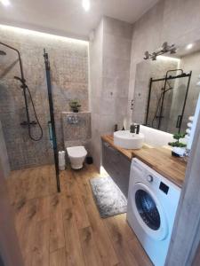 a bathroom with a toilet sink and a washing machine at Urocze kondominium z widokiem na morze in Gdańsk