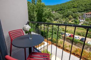 a table and chairs on a balcony with a view at PERUNIKA BED & BREAKFAST in Mošćenička Draga