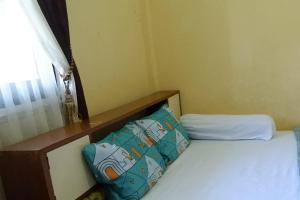 1 dormitorio con 2 camas y ventana en SPOT ON 92760 Global Media Homestay Syariah, en Semarang