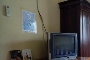 un televisor sentado en una mesa junto a una pared en SPOT ON 92760 Global Media Homestay Syariah, en Semarang