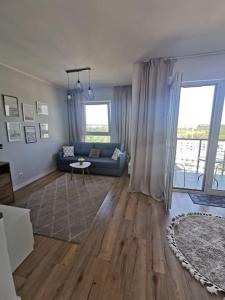 a living room with a blue couch and a table at Urocze kondominium z widokiem na morze in Gdańsk