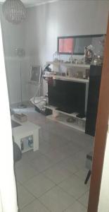 a living room with a television and a tiled floor at F2 idéalement situé J O in La Courneuve