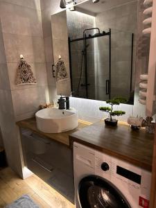 a bathroom with a sink and a washing machine at Urocze kondominium z widokiem na morze in Gdańsk