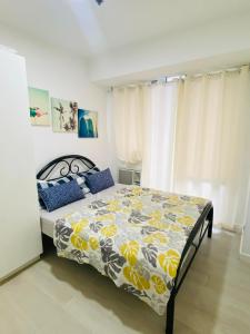 1 dormitorio con 1 cama con edredón amarillo y azul en Pahuwayan1 - an Urban Tropical Retreat, en Manila
