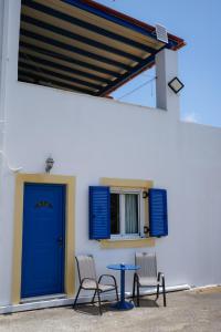a table and two chairs and a blue door at Green Parrot Apartments in Frátsia