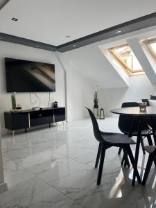 a living room with a tv and a table and chairs at Apartament Mazurski Sen in Giżycko