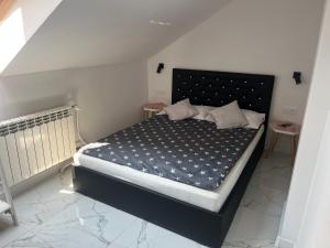 a bedroom with a bed with a black headboard at Apartament Mazurski Sen in Giżycko