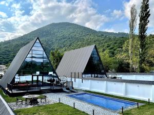 a house with a swimming pool and a mountain at Qafqaz Falcon Chalet in Gabala