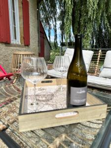 Neuvy的住宿－Maison Bourbonnaise idéalement placée proche du centre ville de Moulins，桌子上放有一瓶葡萄酒和两杯酒