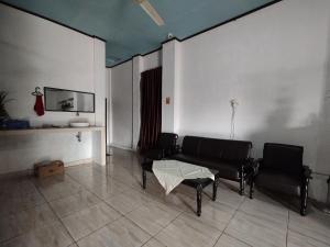 sala de estar con sofá y 2 sillas en OYO 92762 Wisma Pundu Syariah, 