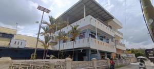 a building with palm trees in front of it at OYO 92762 Wisma Pundu Syariah 