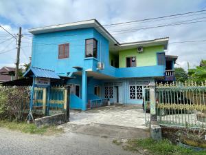 a blue house with a fence in front of it at SPOT ON 92766 Penginapan Asoka Indah in Barru