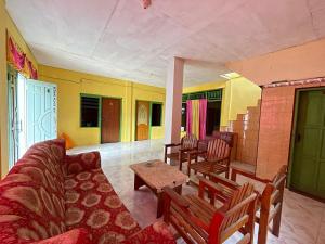 a living room with a couch and a table and chairs at SPOT ON 92766 Penginapan Asoka Indah in Barru