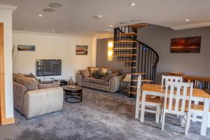 a living room with a couch and a spiral staircase at Skye-Fall in Drumfearn