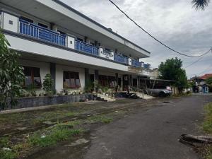 ein Gebäude mit blauen Balkonen auf der Seite in der Unterkunft SPOT ON 92782 Rumah Kost Kita Tarakan in Tarakan